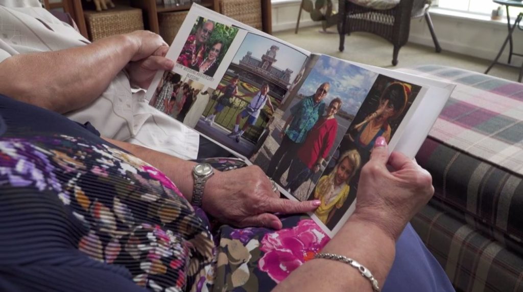  Mary Lou Rodriguez looks a memories in a photo album with her husband. Photo via Ivanhoe Newswire.