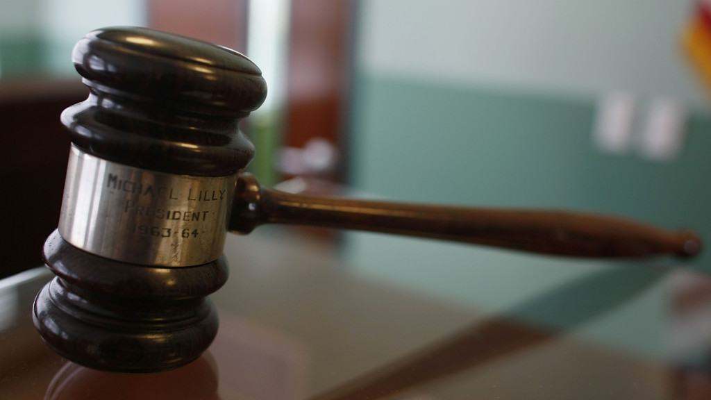 A judges gavel rests on top of a desk in the courtroom. Photo via CBS News.