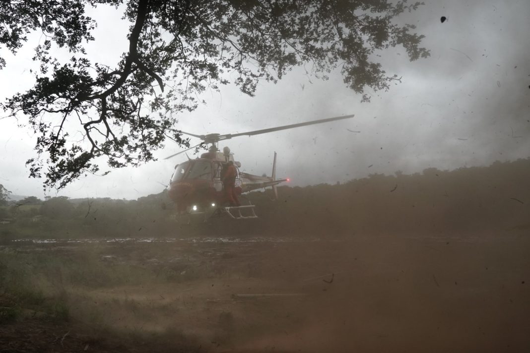 A helicopter takes of carrying a rescued body that was found in the mud, after a dam collapse near Brumadinho, Brazil, Saturday, Jan. 26, 2019. Rescuers in helicopters searched for survivors while firefighters dug through mud in a huge area in southeastern Brazil buried by the collapse of a dam holding back mine waste, with at least nine people dead and up to 300 missing. (AP Photo/Leo Correa)
