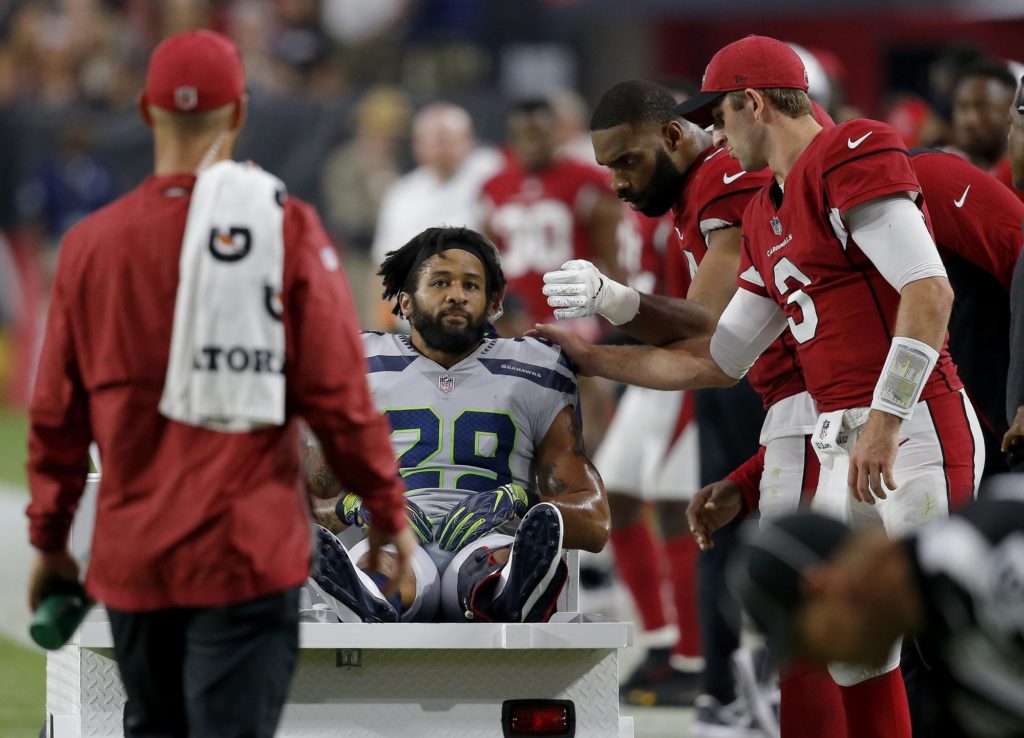 FILE - In this Sept. 30, 2018, file photo, Seattle Seahawks defensive back Earl Thomas (29) is greeted by Arizona Cardinals players as he leaves the field after breaking his leg during the second half of an NFL football game in Glendale, Ariz. Thomas held out through the preseason for a new, cash-up-front, long-term contract in case of a serious injury. Thomas failed to get what he wanted and played instead under his soon-to-expire contract this year until he broke his leg in the fourth game of the season. (AP Photo/Ross D. Franklin, File)