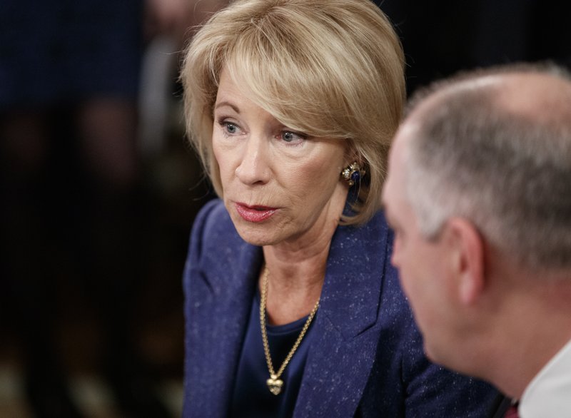 Education Secretary Betsy DeVos, talks with Louisiana Gov. John Bel Edwards before President Donald Trump arrives to speak at the 2019 White House Business Session with Our Nation's Governors in the State Dining Room of the White House in Washington, Monday, Feb. 25, 2019. (AP Photo/Carolyn Kaster)