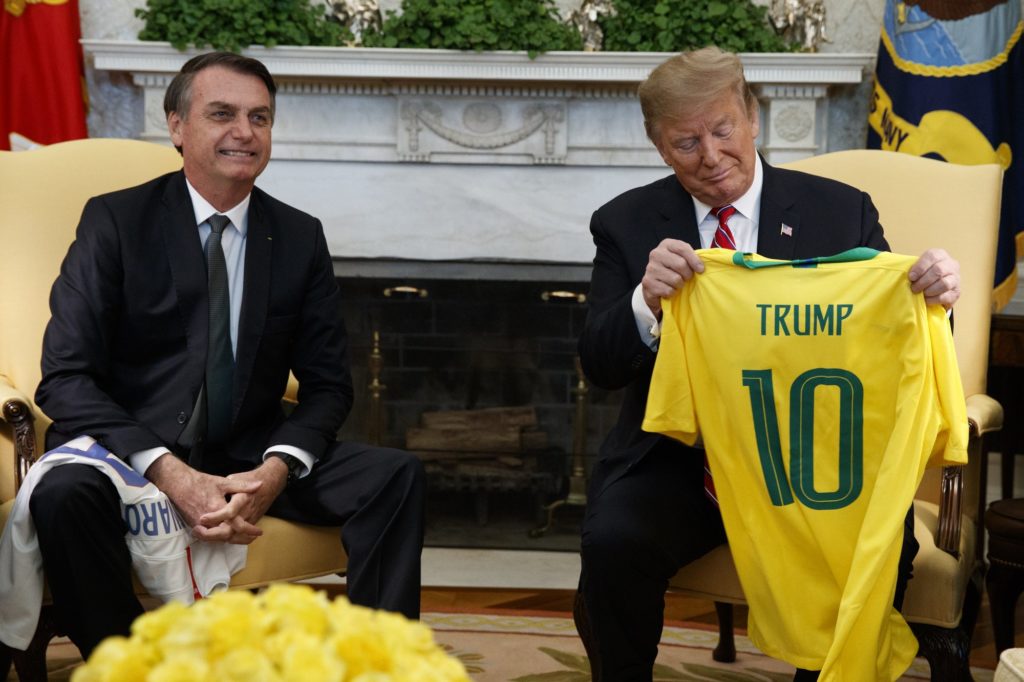 Brazilian President Jair Bolsonaro presents President Donald Trump with a Brazilian national team soccer jersey in the Oval Office of the White House, Tuesday, March 19, 2019, in Washington. (AP Photo/Evan Vucci)
