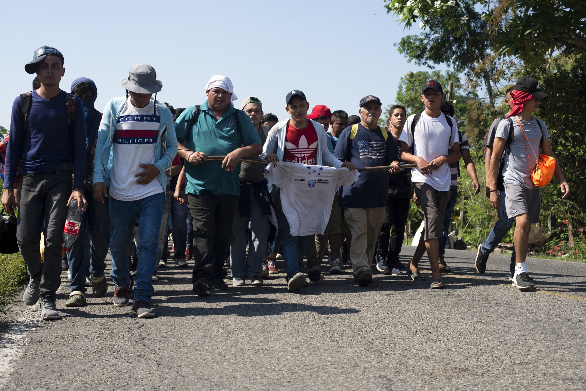 Central American migrants, part of a caravan hoping to reach the U.S. border, walk on a road in Frontera Hidalgo, Mexico, Friday, April 12, 2019. The group pushed past police guarding the bridge and joined a larger group of about 2,000 migrants who are walking toward Tapachula, the latest caravan to enter Mexico. (AP Photo/Isabel Mateos)