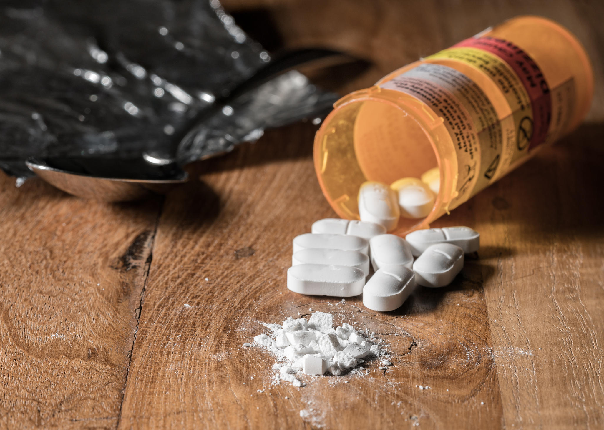 Pills of Oxycodone on a wooden table. (Credit CBS News)