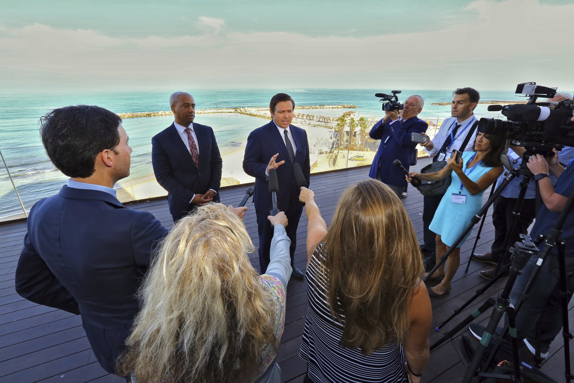 With the Mediterranean Sea as a backdrop, Florida Gov. Ron DeSantis speaks to reporters Monday, May 27, 2019, ahead of the first full day of a Florida trade delegation trip to Israel. DeSantis is leading a delegation on a four-day trade mission to help boost the state's economy and solidify its bonds with Israel. (Jeff Schweers/Tallahassee Democrat via AP)