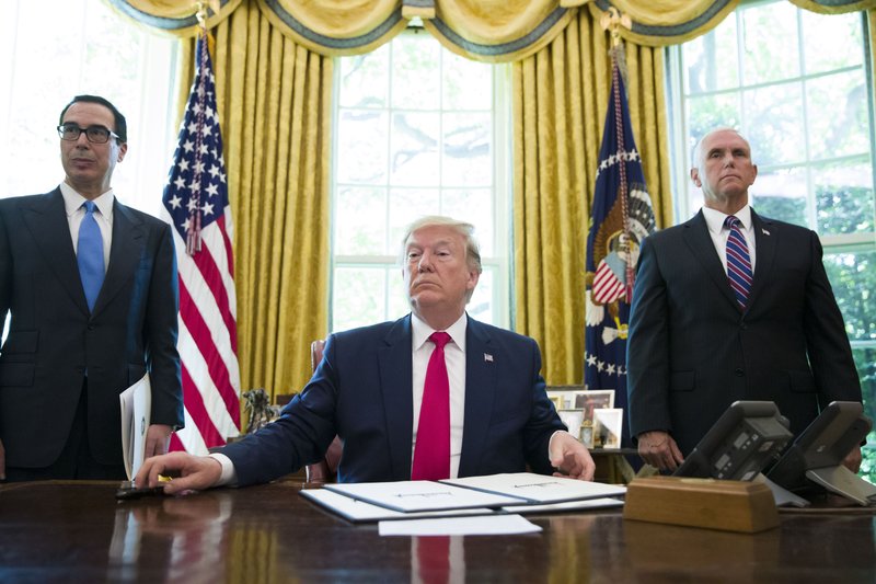 President Donald Trump listens to a reporter's question after signing an executive order to increase sanctions on Iran, in the Oval Office of the White House, Monday, June 24, 2019, in Washington. Trump is accompanied by Treasury Secretary Steve Mnuchin, left, and Vice President Mike Pence. (AP Photo/Alex Brandon)