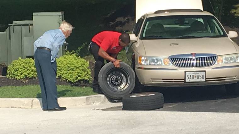 It took Chick-fil-A manager Daryl Howard, right, about 15 minutes to change a flat tire for a 96-year-old WWII veteran employees know as Mr. Lee. (Credit: CBS)