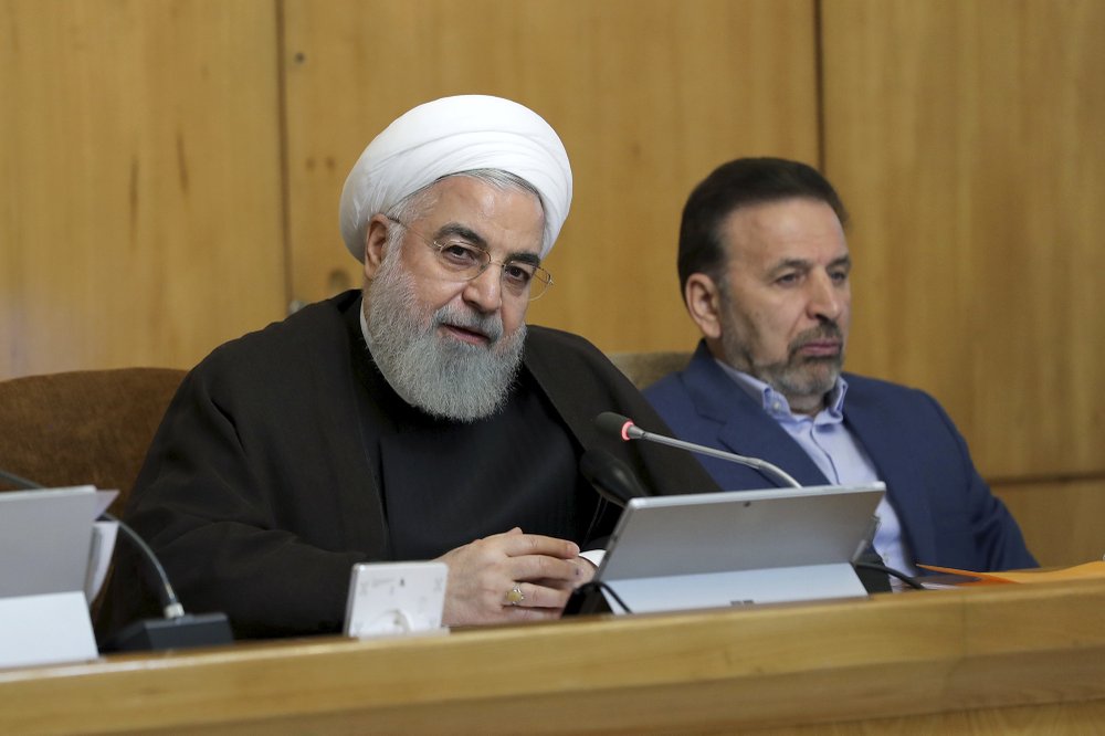 In this photo released by the official website of the office of the Iranian Presidency, President Hassan Rouhani speaks during a cabinet meeting, as President's chief of staff Mahmoud Vaezi sits at right, in Tehran, Iran, Wednesday, July 10, 2019. Rouhani said Wednesday Britain will face "repercussions" over the seizure of an Iranian supertanker. (Iranian Presidency Office via AP)