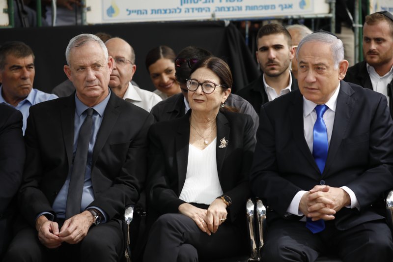 FILE - In this Thursday, Sept. 19, 2019 file photo, Blue and White party leader Benny Gantz, left, Esther Hayut, the Chief Justice of the Supreme Court of Israel, and Prime Minister Benjamin Netanyahu attend a memorial service for former President Shimon Peres in Jerusalem. Israel's two largest political parties are meeting to discuss the possibility of forming a unity government between them, after last week's deadlocked national elections. The Sept. 23 meeting comes a day after Blue and White leader Benny Gantz and Prime Minister Benjamin Netanyahu of the rival Likud party held their first meeting since the polling.(AP Photo/Ariel Schalit, File)