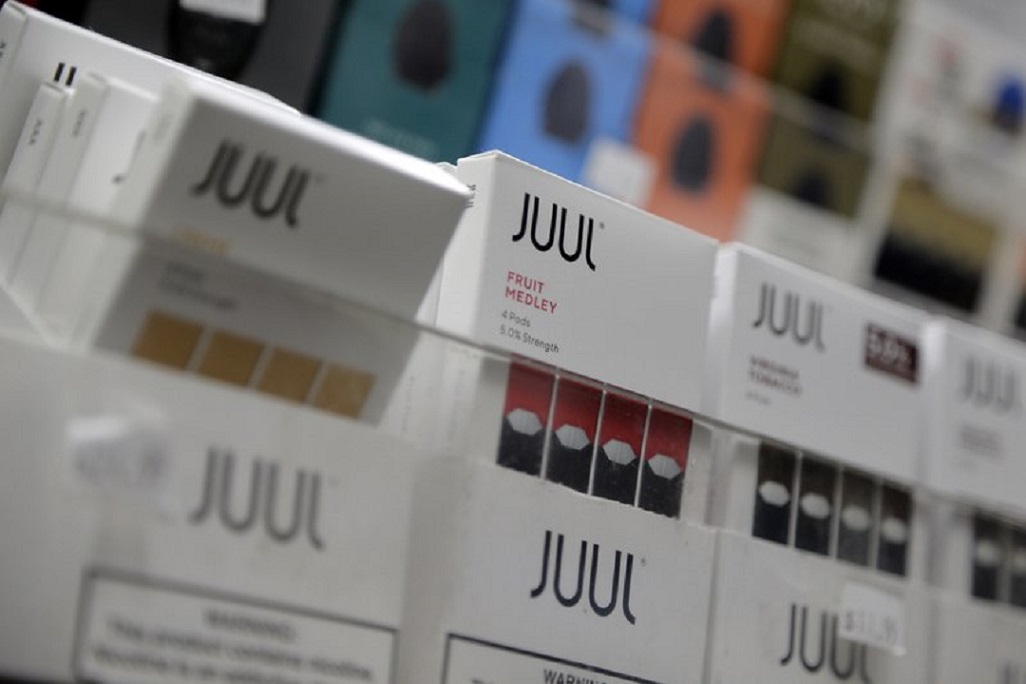 FILE - In this Dec. 20, 2018, file photo Juul products are displayed at a smoke shop in New York. Federal health authorities say vaping giant Juul Labs illegally promoted its electronic cigarettes as a safer option to smoking, including in a presentation to school children. The Food and Drug Administration issued a stern warning letter to the company Monday, Sept. 9, 2019, flagging various claims by Juul, including that its products are “much safer than cigarettes.” The FDA has been investigating Juul for months but had not previously warned the company. (AP Photo/Seth Wenig, File)