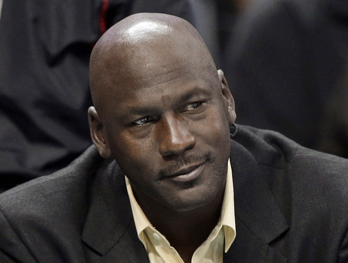 FILE - In this April 16, 2014, file photo, Charlotte Bobcats owner Michael Jordan watches an NBA basketball game between the Bobcats and the Chicago Bulls in Charlotte, N.C. The six-time NBA champion is scheduled to appear Tuesday, Aug. 11, 2015, in federal court in Chicago for the start of a civil trial and will later testify on the unauthorized use of his identity. A court already ruled a grocery-story chain used his identity without permission in a magazine ad and so the unresolved legal issue is damages. (AP Photo/Chuck Burton, File)