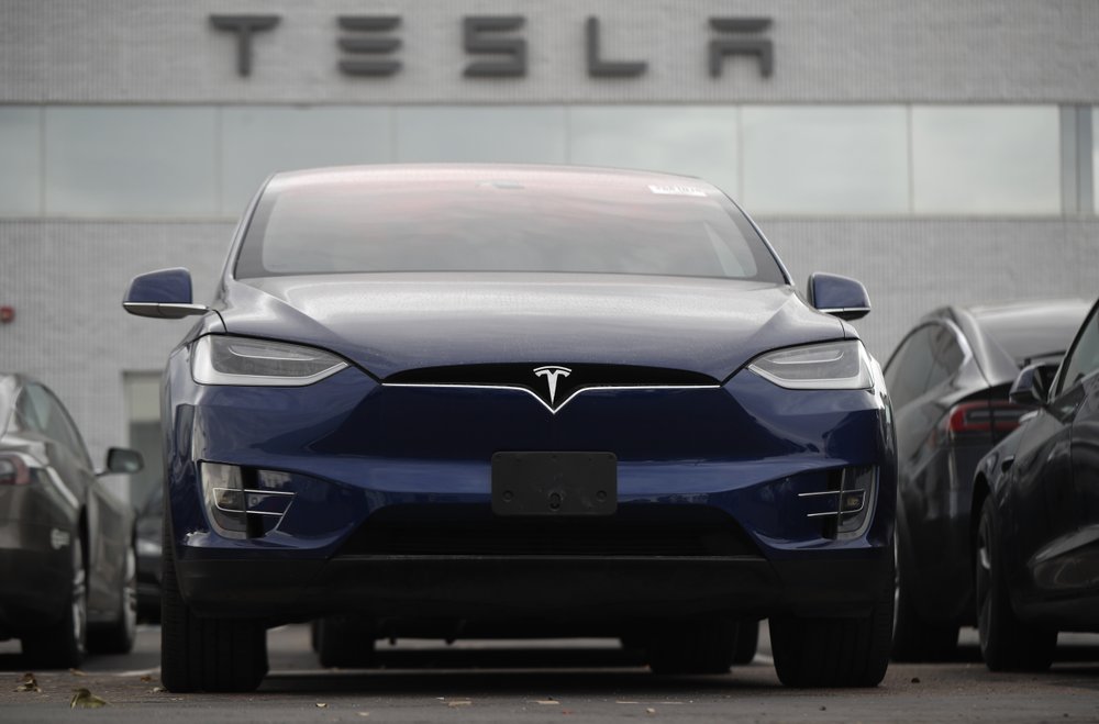 In this Sunday, Oct. 20, 2019, photo an unsold 2019 Model X sits under a sign at a Tesla dealership in Littleton, Colo. Tesla reports financial earns on Wednesday, Oct. 23. (AP Photo/David Zalubowski)