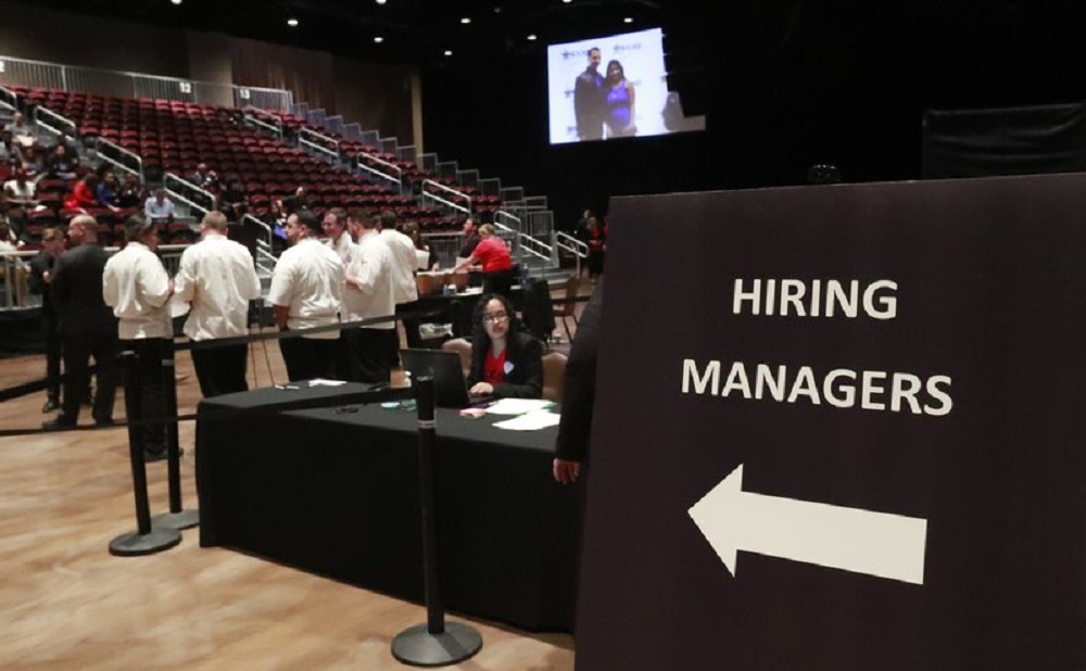 FILE - In this Tuesday, June 4, 2019, file photo, managers wait for job applicants at the Seminole Hard Rock Hotel & Casino Hollywood during a job fair in Hollywood, Fla. A measure of hiring by U.S. companies has fallen to a seven-year low and fewer employers are raising pay, a business survey released Monday, Oct. 28, 2019, has found. Just one-fifth of the firms surveyed by the National Association for Business Economics said they have hired additional workers in the past three months. (AP Photo/Wilfredo Lee, File)