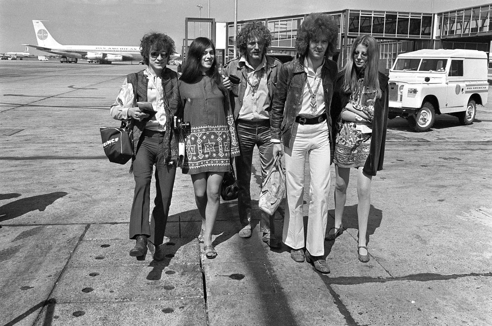 FILE - In this Aug. 20, 1967 file photo, members of the rock group Cream depart from Heathrow Airport in London, for their American tour. The trio, walking with unidentified female companions, from left are, base guitarist Jack Bruce, drummer Ginger Baker, and lead guitarist Eric Clapton. Baker, the volatile and propulsive British musician who was best known for his time with the power trio Cream, died Sunday, Oct. 6, 2019, at age 80, his family said. (AP Photo/Peter Kemp, File)