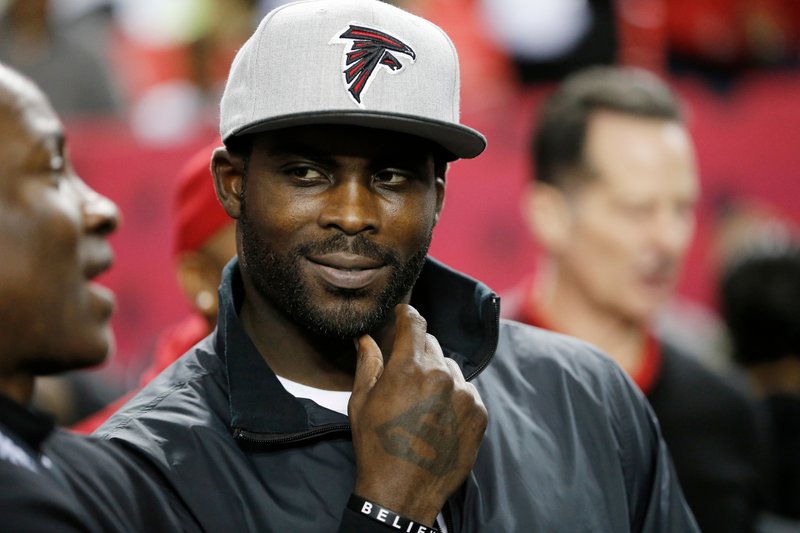 FILE - In this Jan. 1, 2017, file photo, former Atlanta Falcons quarterback Michael Vick stands on the sidelines before an NFL football game between the Falcons and the New Orleans Saints in Atlanta. (AP Photo/John Bazemore, File)