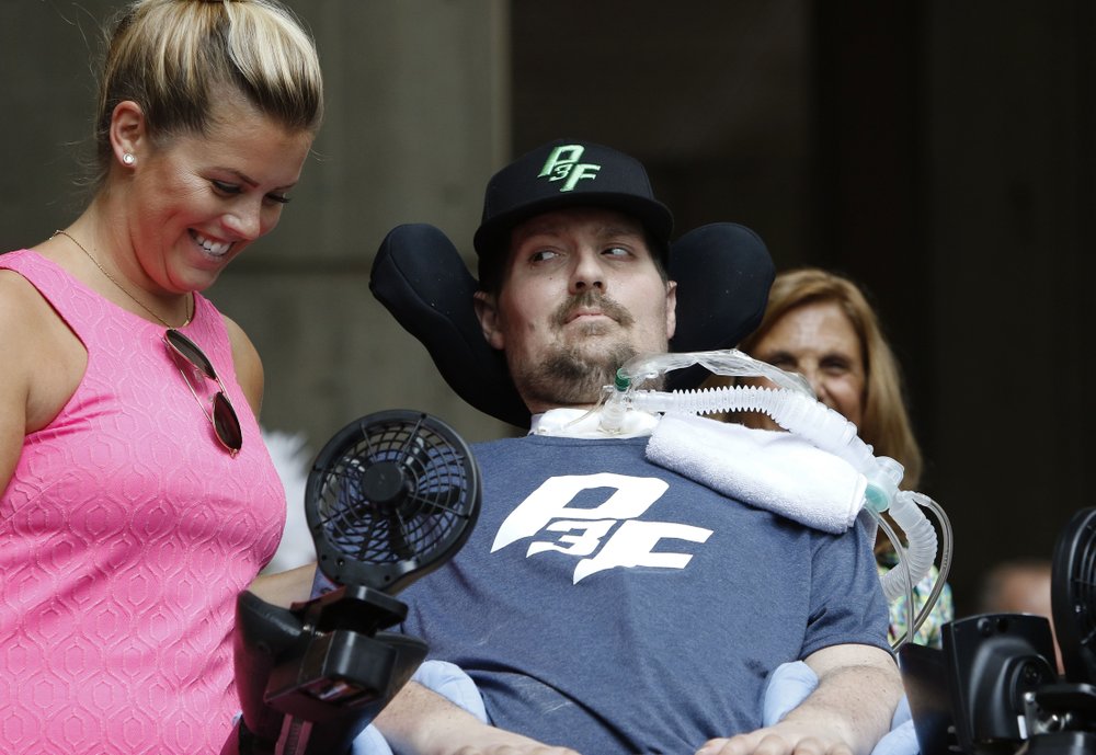 FILE - In this Sept. 5, 2017, file photo, Pete Frates, right, who inspired the ice bucket challenge, looks at his wife Julie during a ceremony at City Hall in Boston by Boston Mayor Marty Walsh declaring the day the Pete Frates Day. Frates, who was stricken with amyotrophic lateral sclerosis, or ALS, died Monday, Dec. 9, 2019. He was 34. (AP Photo/Bill Sikes, File)