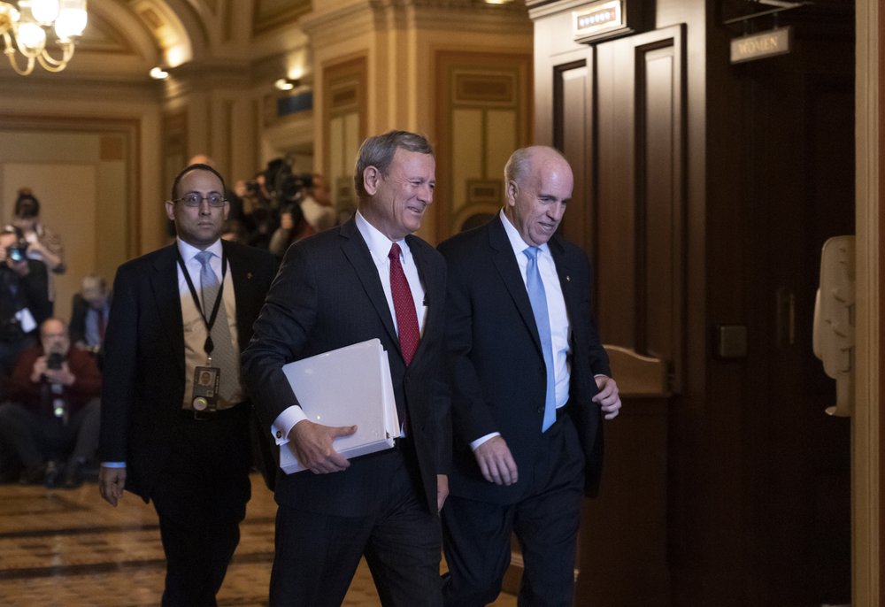 Chief Justice of the United States John Roberts arrives at the Senate to preside at the impeachment trial of President Donald Trump on charges of abuse of power and obstruction of Congress, at the Capitol in Washington, Thursday, Jan. 16, 2020. He is escorted by Senate Sergeant at Arms Michael Stenger, right. (AP Photo/J. Scott Applewhite)