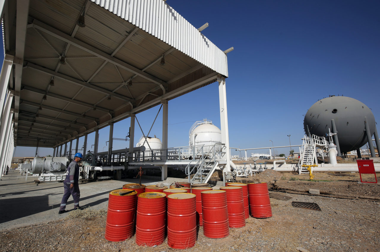 An Iraqi oil employee walks past oil barrels at the Bai Hassan oil field, west of the multi-ethnic northern Iraqi city of Kirkuk, on October 19, 2017. Kurdish peshmerga forces withdrew without a fight after federal government troops and militia entered Kirkuk, seizing the provincial governor's office and key military bases in response to a Kurdish vote for independence in September 2017. / AFP PHOTO / AHMAD AL-RUBAYE (Photo credit should read AHMAD AL-RUBAYE/AFP via Getty Images)