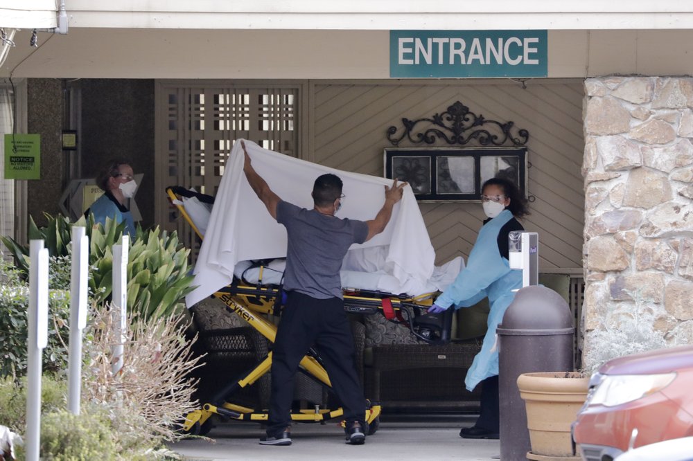A person is taken by stretcher to a waiting ambulance from a nursing facility where more than 50 people are sick and being tested for the COVID-19 virus, Saturday, Feb. 29, 2020, in Kirkland, Wash. (AP Photo/Elaine Thompson)